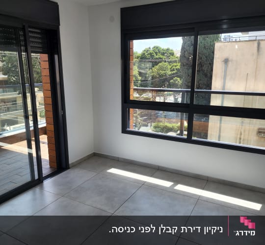 חדר ריק עם רצפת אריחים נקייה וחלונות גדולים